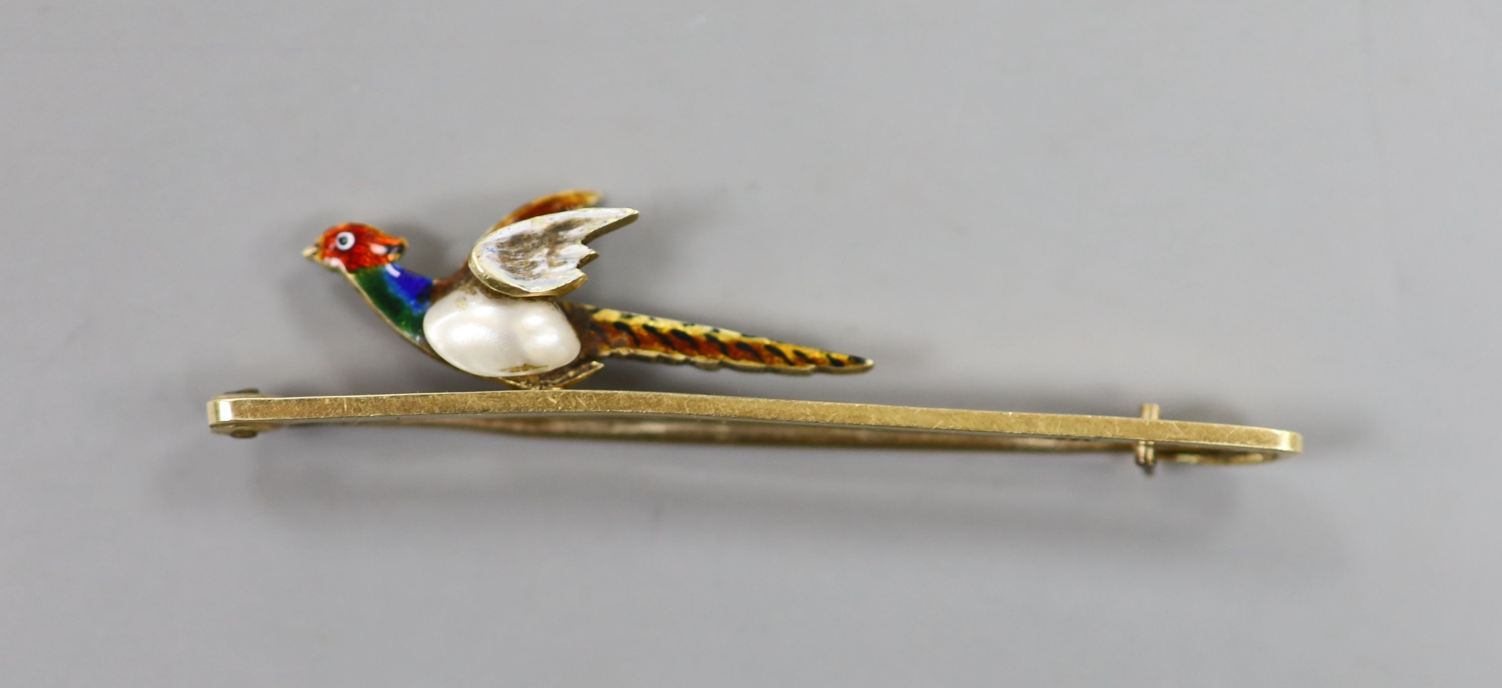 An Edwardian 15ct, baroque pearl and enamel pheasant bar brooch, 51mm, gross weight 4 grams.